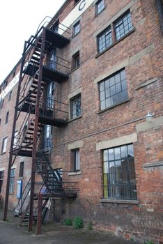 rusty fire escape stairs in a old brick wall building