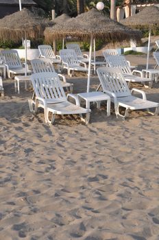 resort beach with chairs and umbrellas (during sunset)