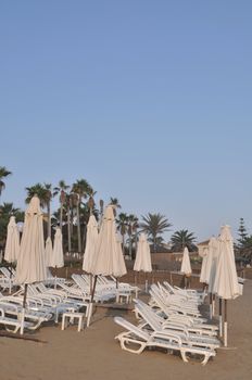 resort beach with chairs and umbrellas (during sunset)