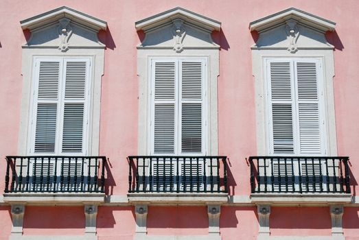 close up of a residential pink building (typical windows)