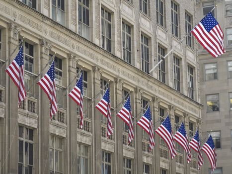 many american flags hissed on one building