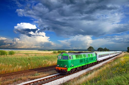 Intercity train passing the countryside with colorful sky over