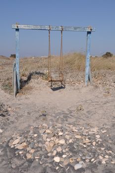 old and rusty swing on a Greek beach