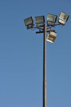 stadium lights pole against blue sky background