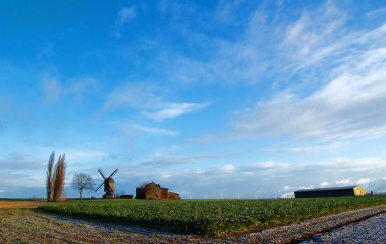 Morning light,field, traditional windmill and house, modern windmill generators on a background