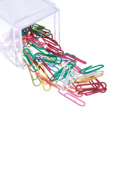 colored paper clips outside a plastic box isolated on white background