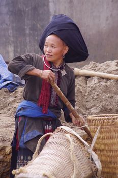 Female , woman , Black Dao minority in the region of Lai Chau. Here this woman is the earthworks for the arrival of running water from a house in the nearby town.
