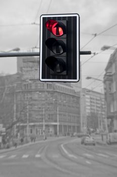 Red color on the traffic light against city background