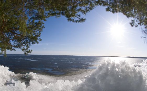 sunny lake with ice and bright shining sun