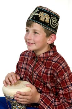 A boy  in the national hat , plays on the Bedouin drum tarbuka
