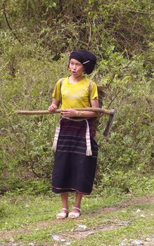Woman of the ethnic Lu from the fields. It was a departure from its traditional dress, but retained the traditional headdress and robe traditionally striped horizontally.