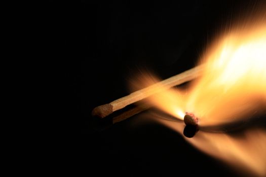 Match bursting into flames on black