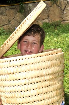 	
A boy plays hide and seek in the look of the basket
