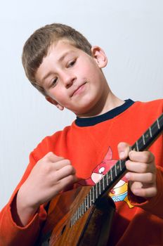 	
A boy plays balalaika Russian folk musical instrument