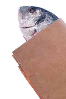 raw dorado fish on market paper bag (isolated on white background)