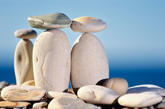 Three small stones balancing on long cobblestones