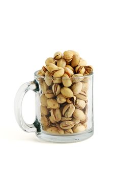 Low glass beer mug filled with salted pistachios isolated on white background