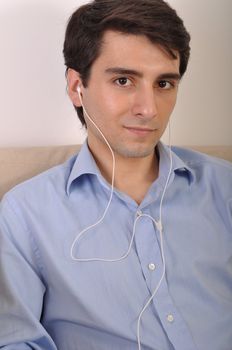 attractive young man listening to music on the couch