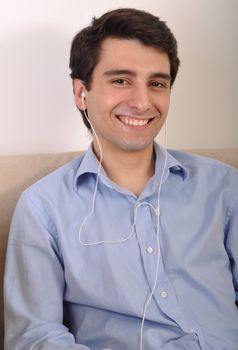 attractive young man listening to music on the couch