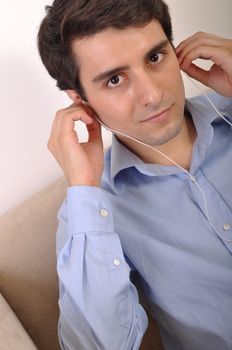 attractive young man listening to music on the couch