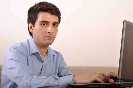 attractive young man with laptop computer sitting on the couch at home