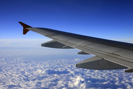 Wing of the plane on a background of clouds
