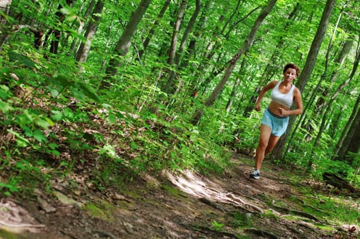 Mature woman running in forest.