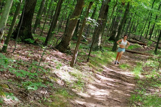 Mature woman running in forest.