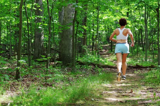 Mature woman running in forest.