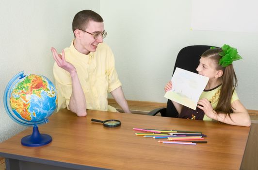 The girl shows new drawing to the brother