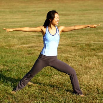 Girl practicing yoga in a summer meadow.