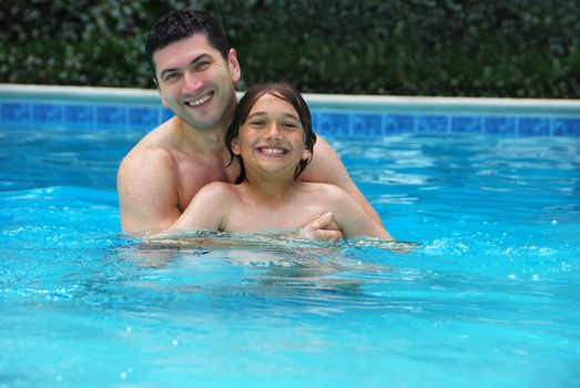 Son and dad enjoying the swimming pool.