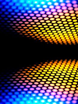 A metalic reflective surface back lit by a colorful light.