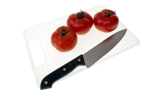 Cutting board with a knife and tomato isolated on a white background.
