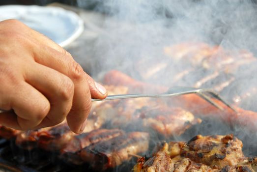 various meat grilled on barbecue in smoke closeup