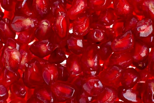 Macro up view of peeled red ripe pomegranate seeds.