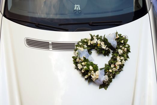 wedding wreath decoration in heart shape on white car