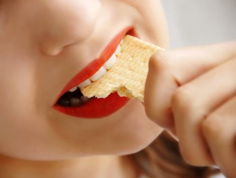 young girl opened mouth biting a cookie