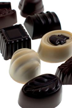 Delicious dark, milk, and white chocolate pralines isolated on white background.