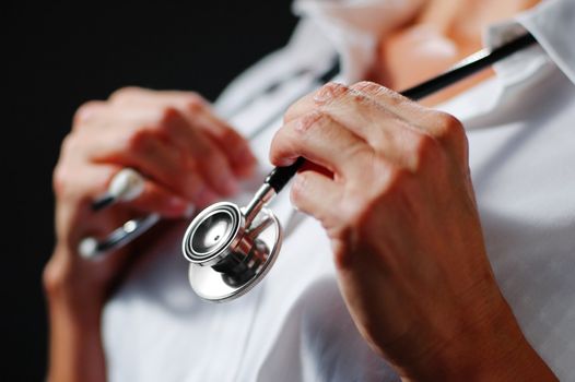 Close up of stethoscope being held by older womans hands.