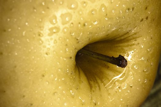 close up shot of a yellow apple with some drops of water