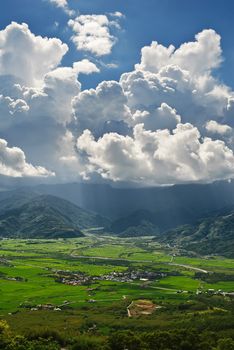 Dramatic landscape of town under cloudy sky in daytime.