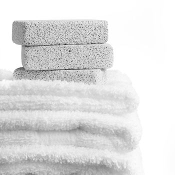 Pumice stones and towels against a white background.