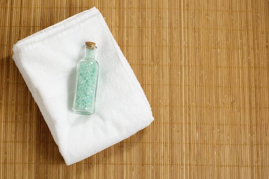 Bottle of bath salt and towel on display.