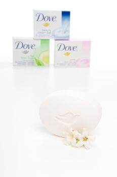 Three varieties of Dove beauty cream soap bars with a foreground soap in focus with jasmine flower.  White background.  Editorial use only.