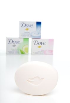 A variety of Dove beauty cream soaps in the background, with one soap with the Dove emblem in the foreground focus.  White background.  Editorial use only.