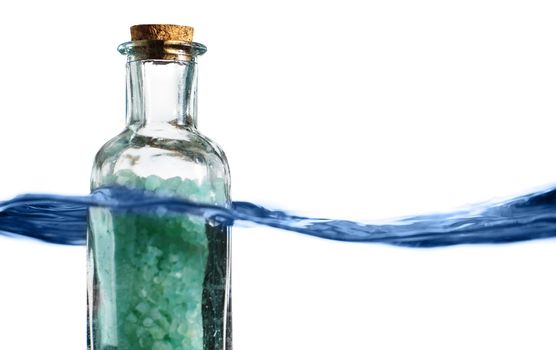 Bottle of bath salts sitting in a blue wave of water.