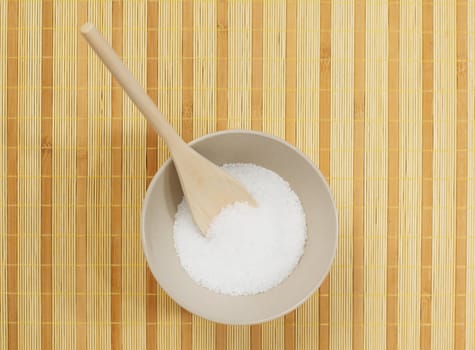 Bowl on a bamboo mat filled with bath salt.