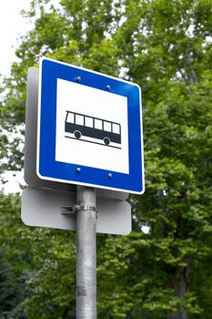 Bus stop sign with trees in the background