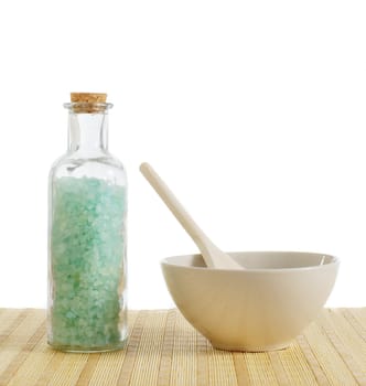 Bottle of salt and bowl of treatment against a white background.